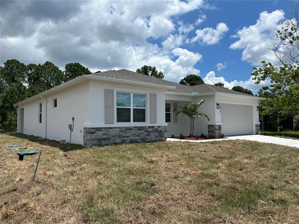 A single-story house with a white exterior, stone accents, and a two-car garage — 2623 JUPITER BOULEVARD SW, PALM BAY, FL