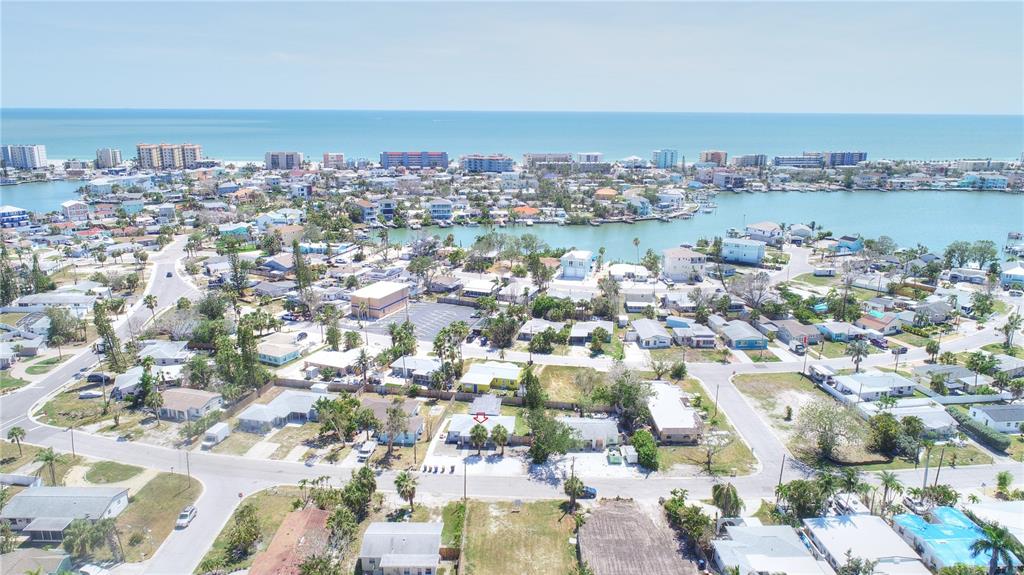 An aerial view shows a residential neighborhood with a house marked by a red arrow — 14026 E PARSLEY DRIVE, MADEIRA BEACH, FL