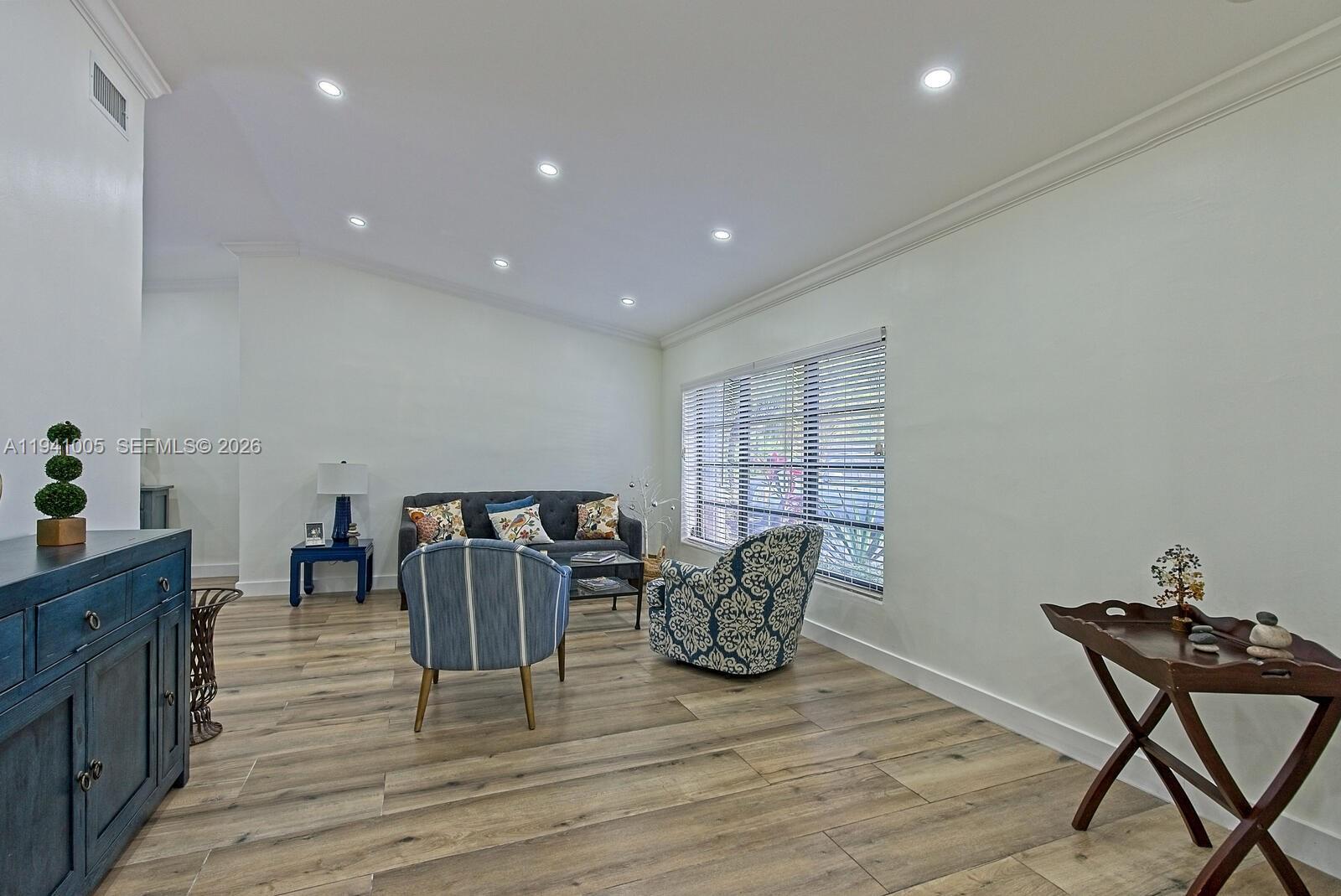 A living room features light wood-look flooring, white walls, recessed lighting, and assorted furniture — 10900 SW 124th Rd, Miami FL 33176, MIAMI, FL