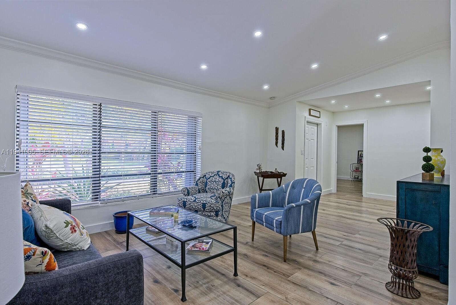 A living room features light wood-look flooring, a glass coffee table, and patterned accent chairs — 10900 SW 124th Rd, Miami FL 33176, MIAMI, FL