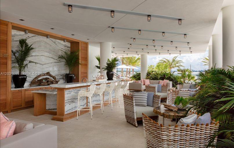 An open-air lounge features a marble-topped bar, wicker seating, and views of palm trees — 2900 NE 7th Ave # 2901, Miami FL 33137, MIAMI, FL