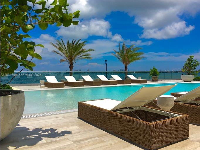 A swimming pool with lounge chairs overlooks a bay under a blue sky — 2900 NE 7th Ave # 2901, Miami FL 33137, MIAMI, FL