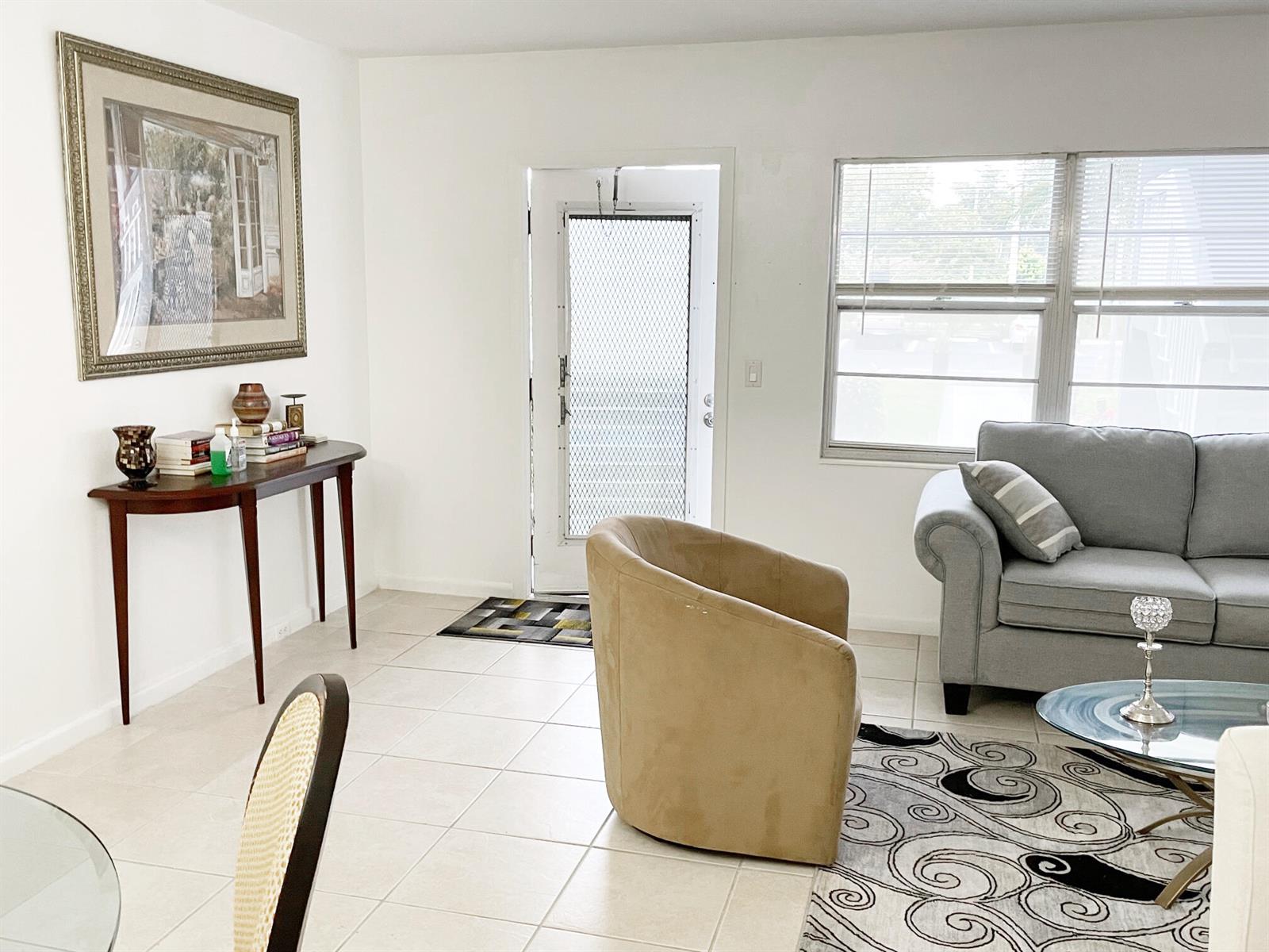 A living room features tile flooring, a gray sofa, a tan armchair, and a console table — 171 Suffolk F # 171, Boca Raton FL 33434, BOCA RATON, FL