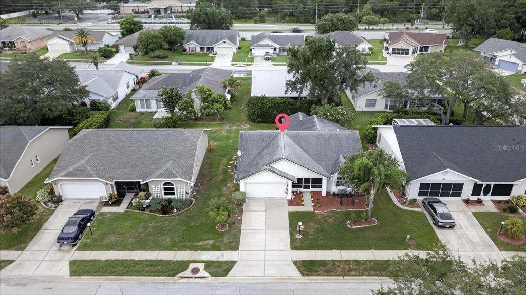 An aerial view shows a suburban house with a white garage and a red pin — 10508 QUIMBY DRIVE, PORT RICHEY, FL