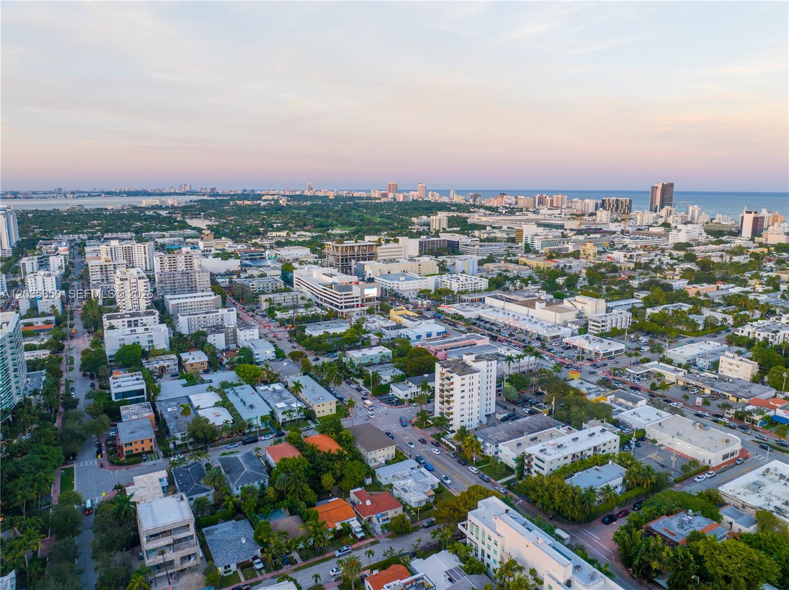 An aerial view of a dense urban neighborhood with low-rise buildings and distant coastal skyscrapers — 1330 West Ave # 3009, Miami Beach FL 33139, MIAMI BEACH, FL