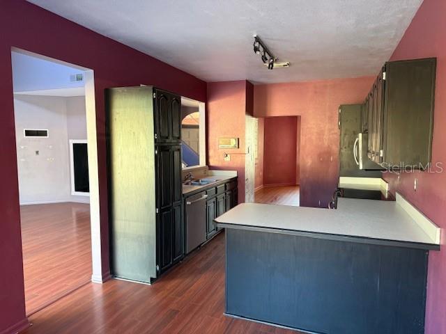 A kitchen features dark cabinets, a white countertop, and wood-look flooring — 450 LONGMEADOW LANE, LONGWOOD, FL
