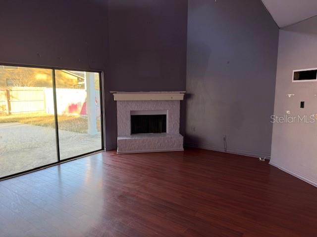 A living room features dark wood flooring, a white fireplace, and a large sliding glass door — 450 LONGMEADOW LANE, LONGWOOD, FL