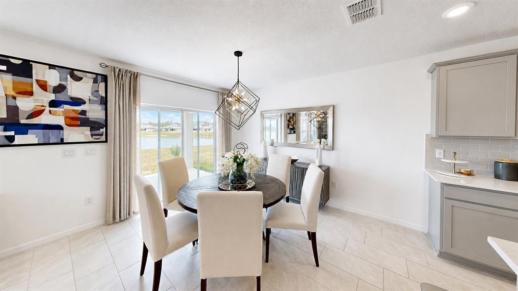A dining room features a round table, four upholstered chairs, and a geometric pendant light — 3884 CAPRI COAST DRIVE, PLANT CITY, FL