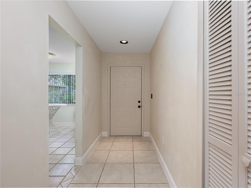 A tiled entryway features a light-colored front door and an adjacent doorway to a room — 109 WATERWOOD DRIVE, YALAHA, FL