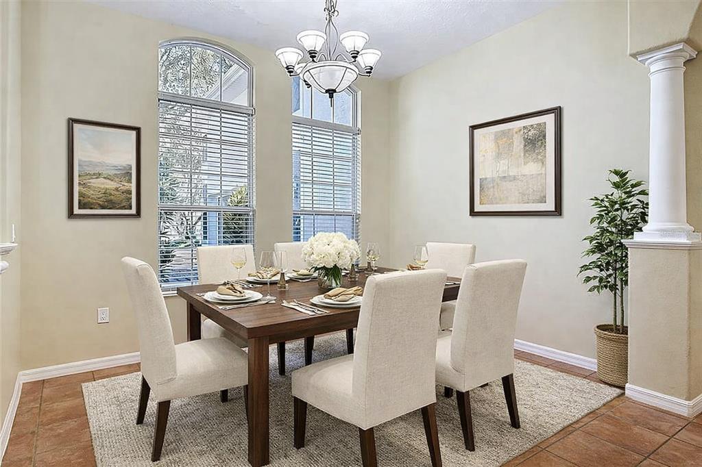 A dining room features a wooden table with six chairs, a chandelier, and two windows — 949 HAWK LANDING, FRUITLAND PARK, FL
