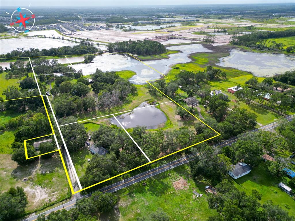 An aerial view shows several rural land parcels outlined in yellow with trees and ponds — 22839 BUNGALOW LANE, LAND O LAKES, FL