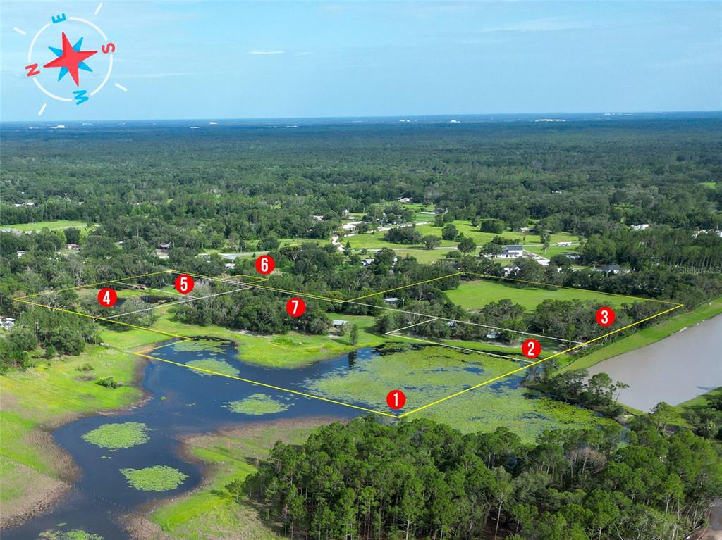 An aerial view shows a large plot of land with a pond and numbered markers — 22839 BUNGALOW LANE, LAND O LAKES, FL