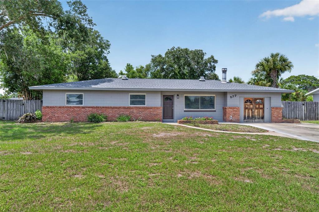 A single-story house with a gray exterior, brick base, and a concrete driveway — 577 PARKDALE COURT, DELAND, FL