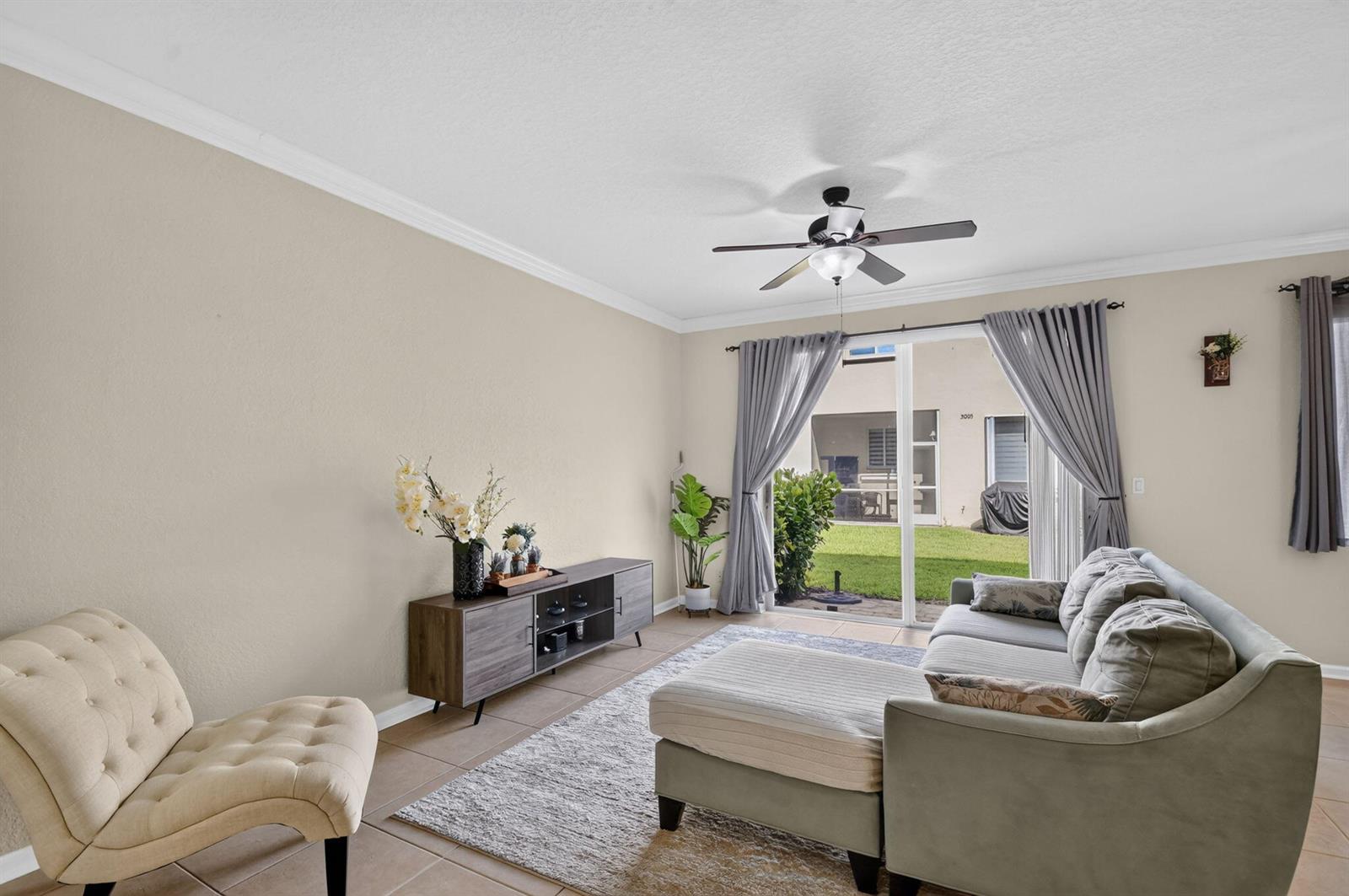 A living room features a sectional sofa, a media console, and a sliding glass door — 3117 N Evergreen Circle, Boynton Beach FL 33426, BOYNTON BEACH, FL