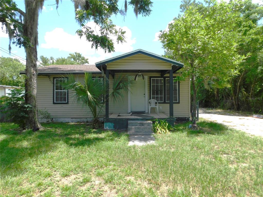 A single-story house with beige siding, a covered front porch, and a grassy yard — 306 FLORIDA DRIVE, PALATKA, FL