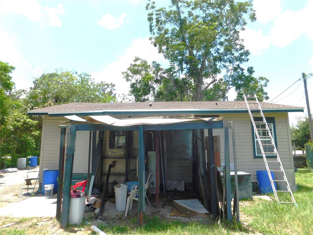 The exterior of a house features a metal-framed porch structure and a leaning extension ladder — 306 FLORIDA DRIVE, PALATKA, FL