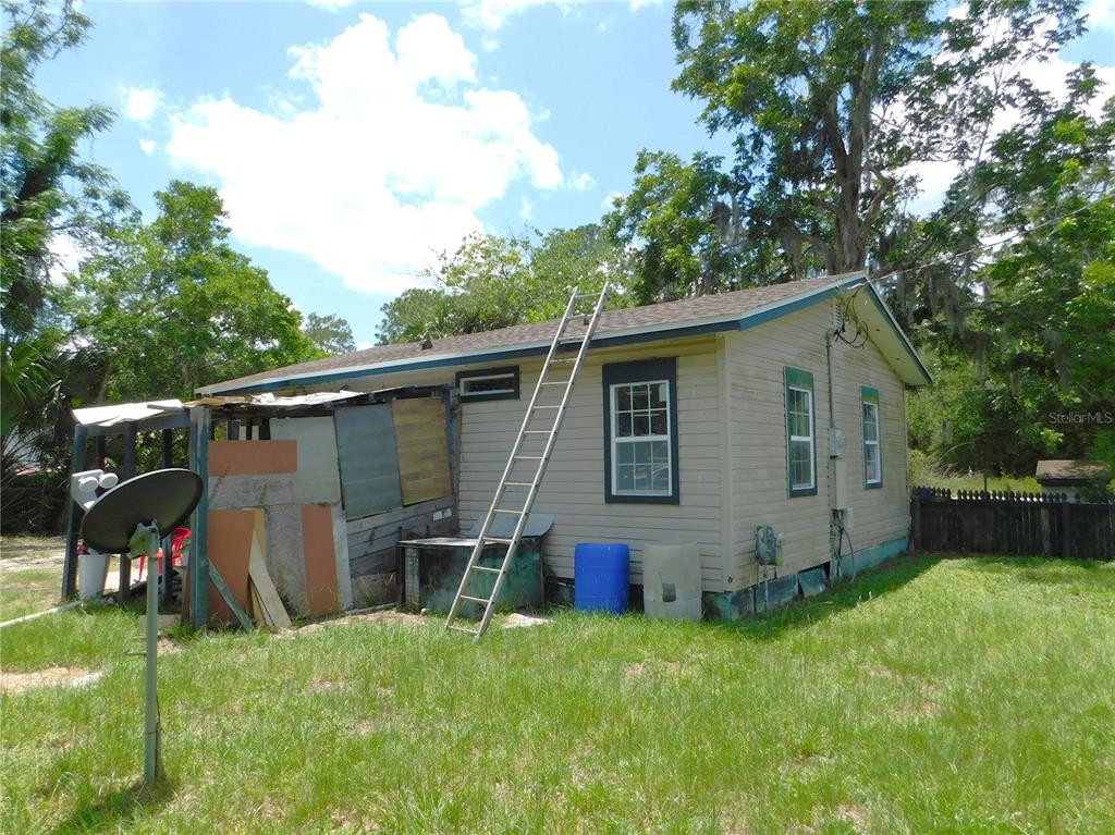 A side view of a single-story house with a ladder leaning against the roof — 306 FLORIDA DRIVE, PALATKA, FL