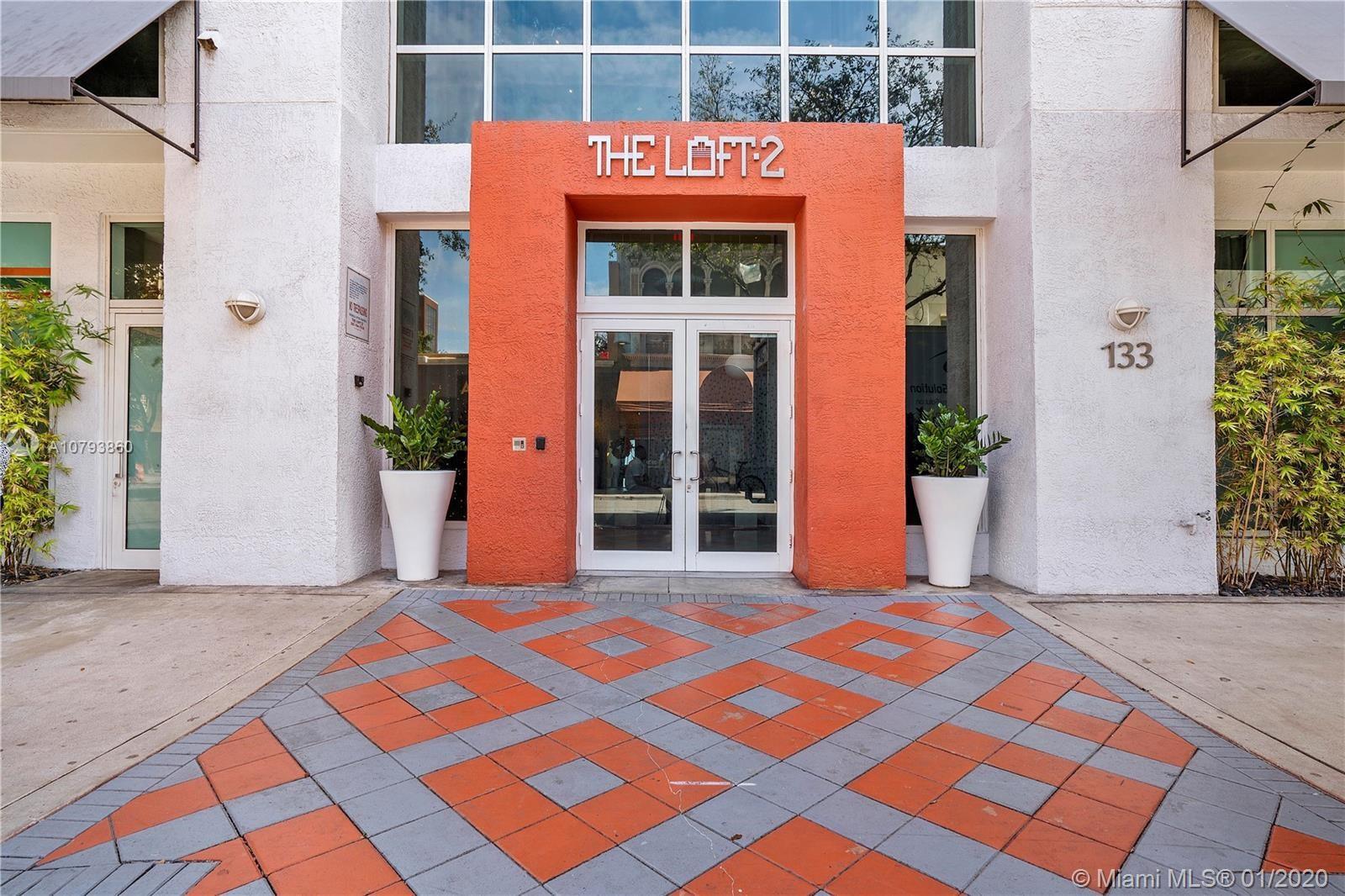 The exterior entrance of a building features a bright orange facade and a patterned walkway — 133 NE 2nd Avenue, Miami FL 33132, MIAMI, FL