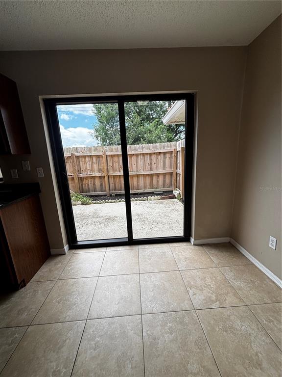 A dining area with tile flooring and a sliding glass door leading to a patio — 1627 LONG RIDGE COURT UNIT 270, ORLANDO, FL