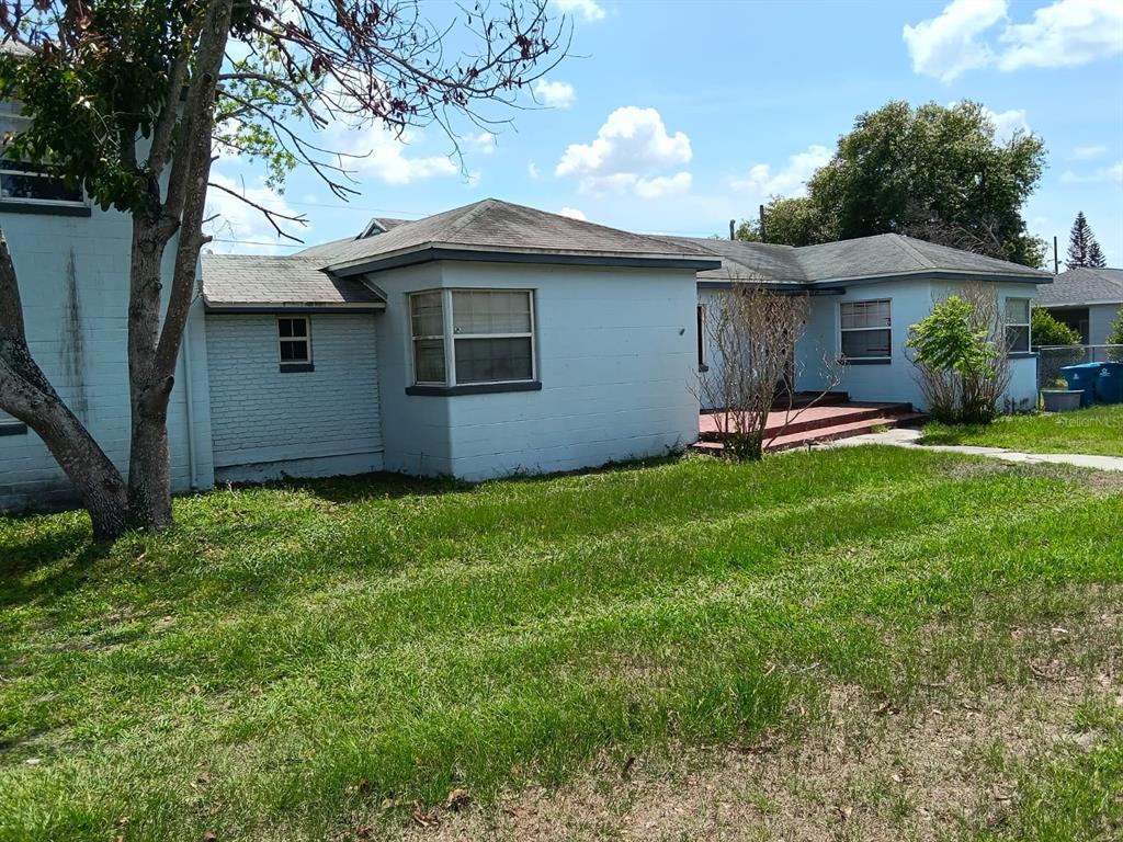 A light blue, single-story house with a hip roof and a small front porch — 1011 NE 2ND STREET, MULBERRY, FL