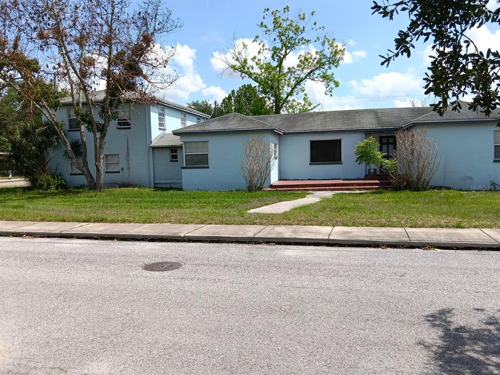 A light blue, two-story house with a single-story wing and a front lawn — 1011 NE 2ND STREET, MULBERRY, FL