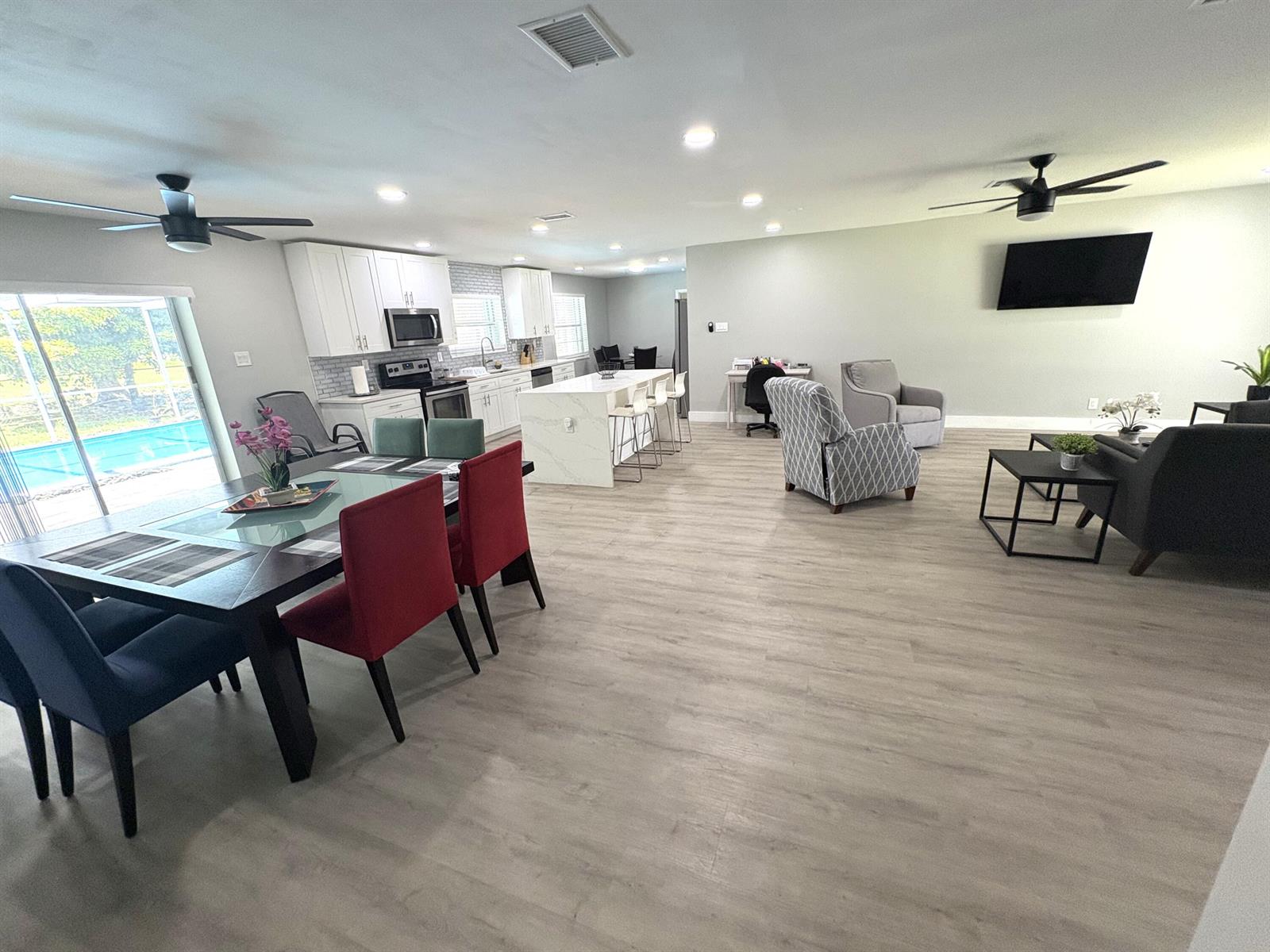 An open-concept living area features a kitchen with white cabinetry, a dining set, and flooring — 1401 NW 75th Terrace, Plantation FL 33313, PLANTATION, FL
