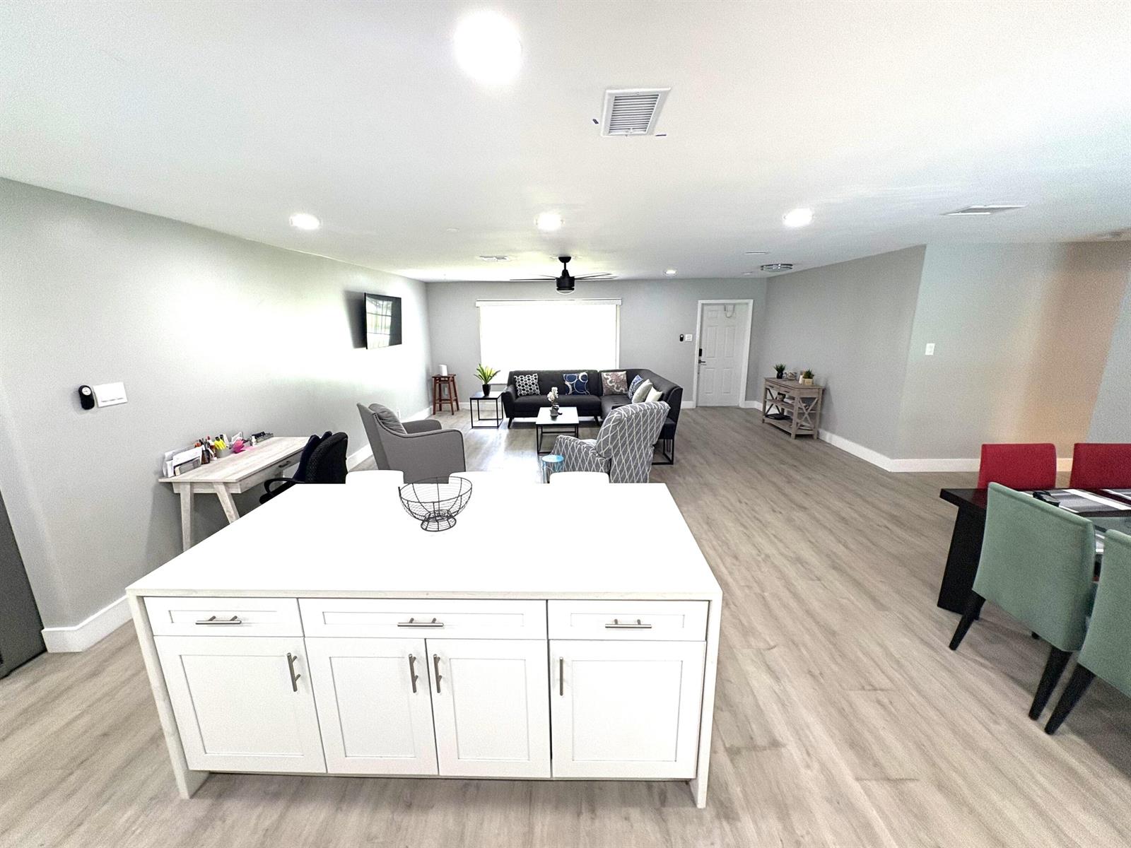 An open-concept living area features a kitchen island, dining table, and a sectional sofa — 1401 NW 75th Terrace, Plantation FL 33313, PLANTATION, FL