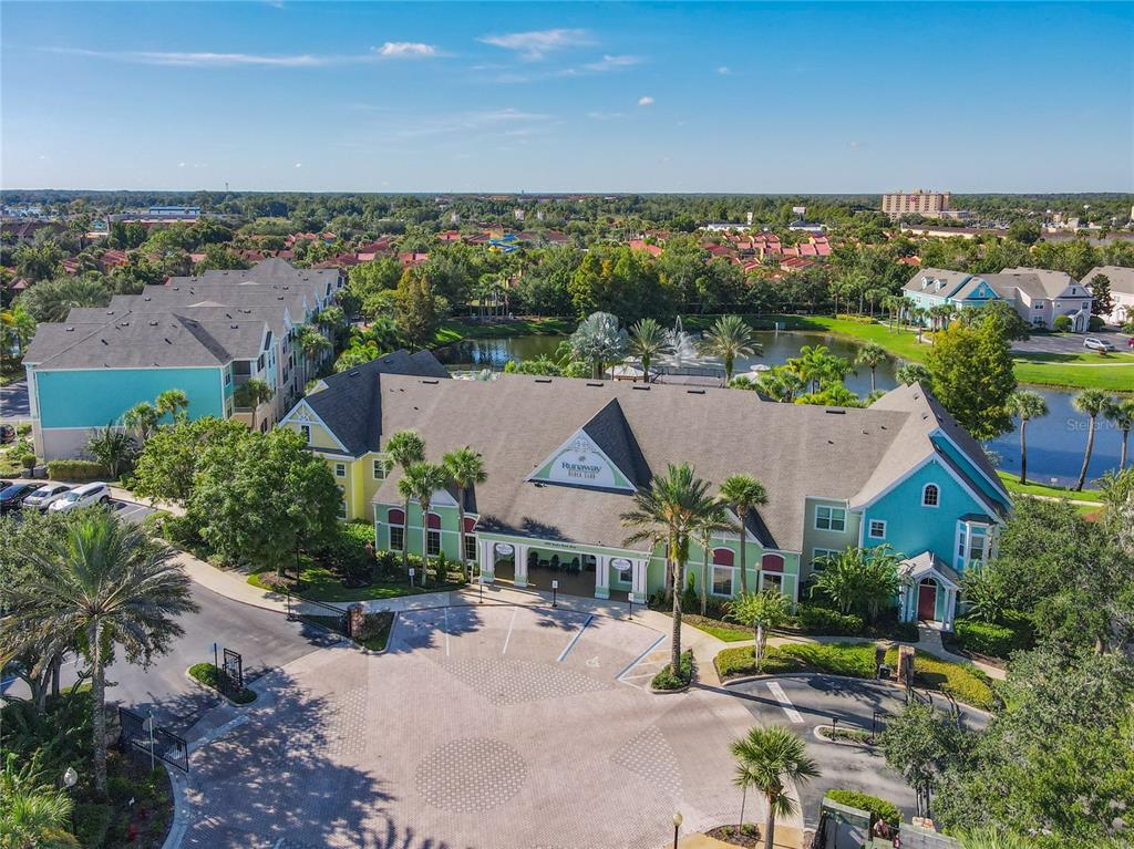 An aerial view of a multi-story clubhouse building with a pool and fountain behind it — 3002 BONFIRE BEACH DRIVE UNIT 202, KISSIMMEE, FL