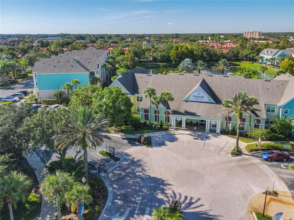 An aerial view shows a multi-story apartment complex with a paved courtyard and palm trees — 3002 BONFIRE BEACH DRIVE UNIT 202, KISSIMMEE, FL
