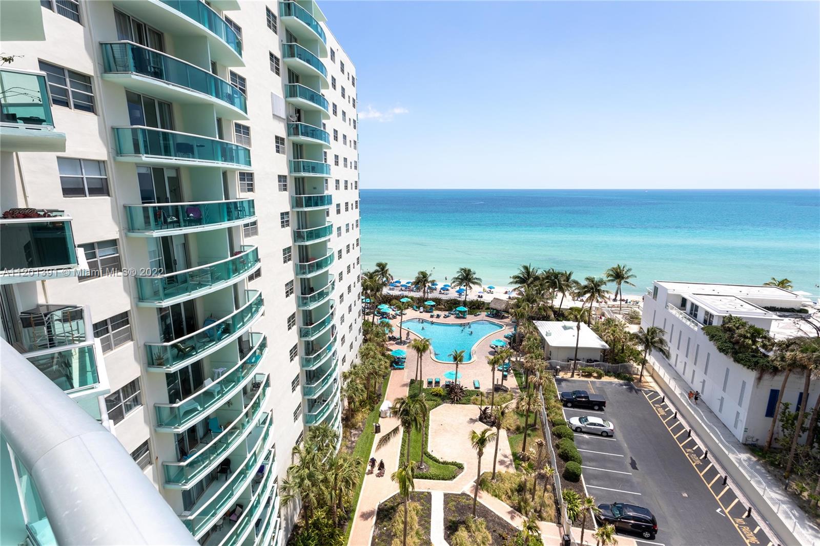 An elevated view shows a high-rise building with balconies overlooking a swimming pool and ocean — 3901 S Ocean Dr # 10M, Hollywood FL 33019, HOLLYWOOD, FL