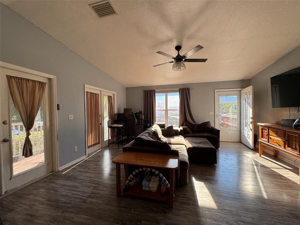 A kitchen features wood cabinets, stainless steel appliances, and a window with gray curtains — 38932 CENTRAL AVENUE, ZEPHYRHILLS, FL