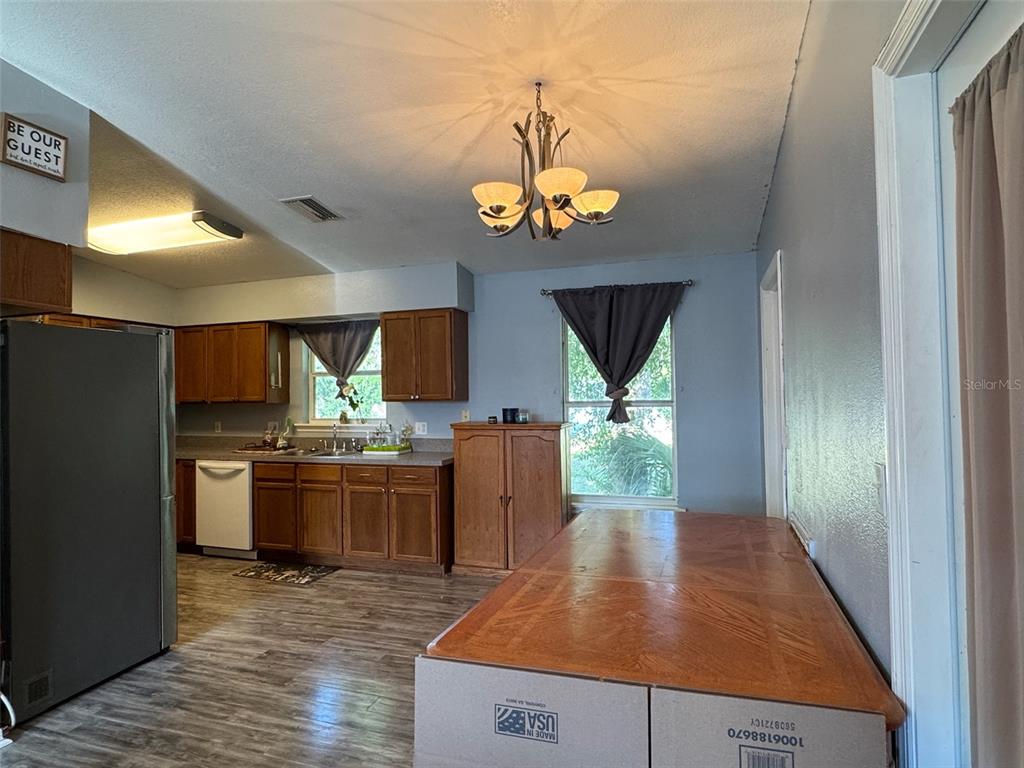 A kitchen features wood cabinets, stainless steel appliances, a white stove, and a double sink — 38932 CENTRAL AVENUE, ZEPHYRHILLS, FL