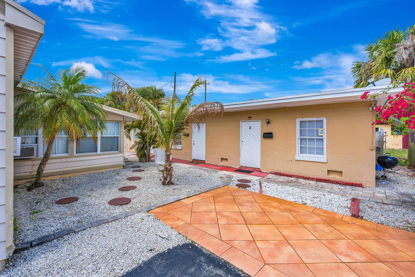 A small kitchen features white cabinets, a black stove, a microwave, and tile flooring — 505 Foresteria Drive, Lake Park FL 33403, LAKE PARK, FL