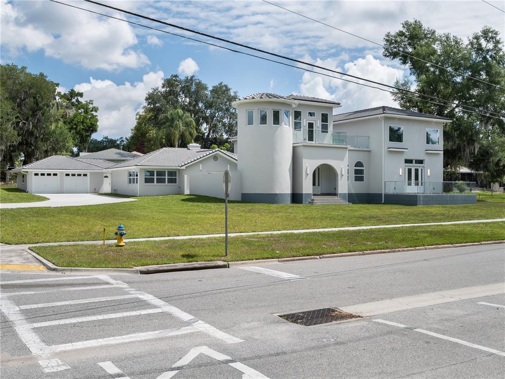 A two-story house with a prominent circular tower and a multi-car garage — 1190 W LAKESHORE DRIVE, CLERMONT, FL