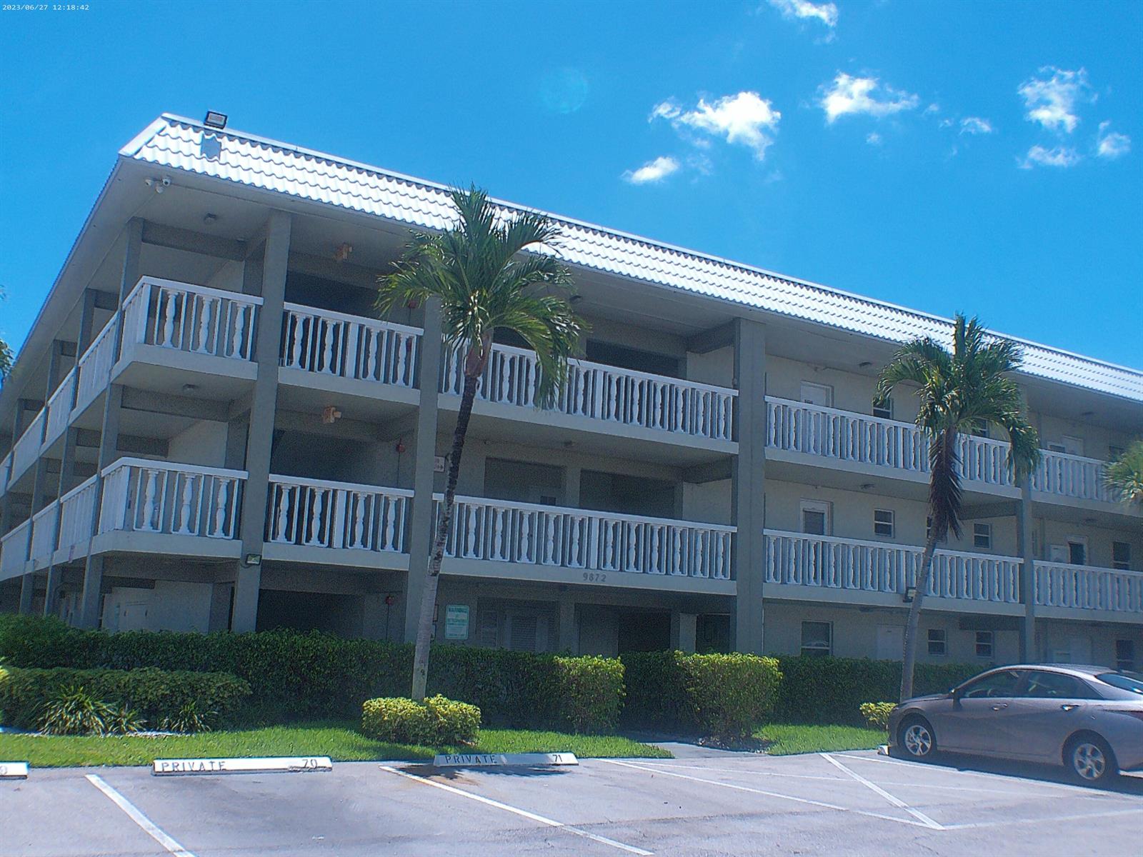 A three-story apartment building with white railings and palm trees in the parking lot — 9872 Marina Boulevard # 1434, Boca Raton FL 33433, BOCA RATON, FL