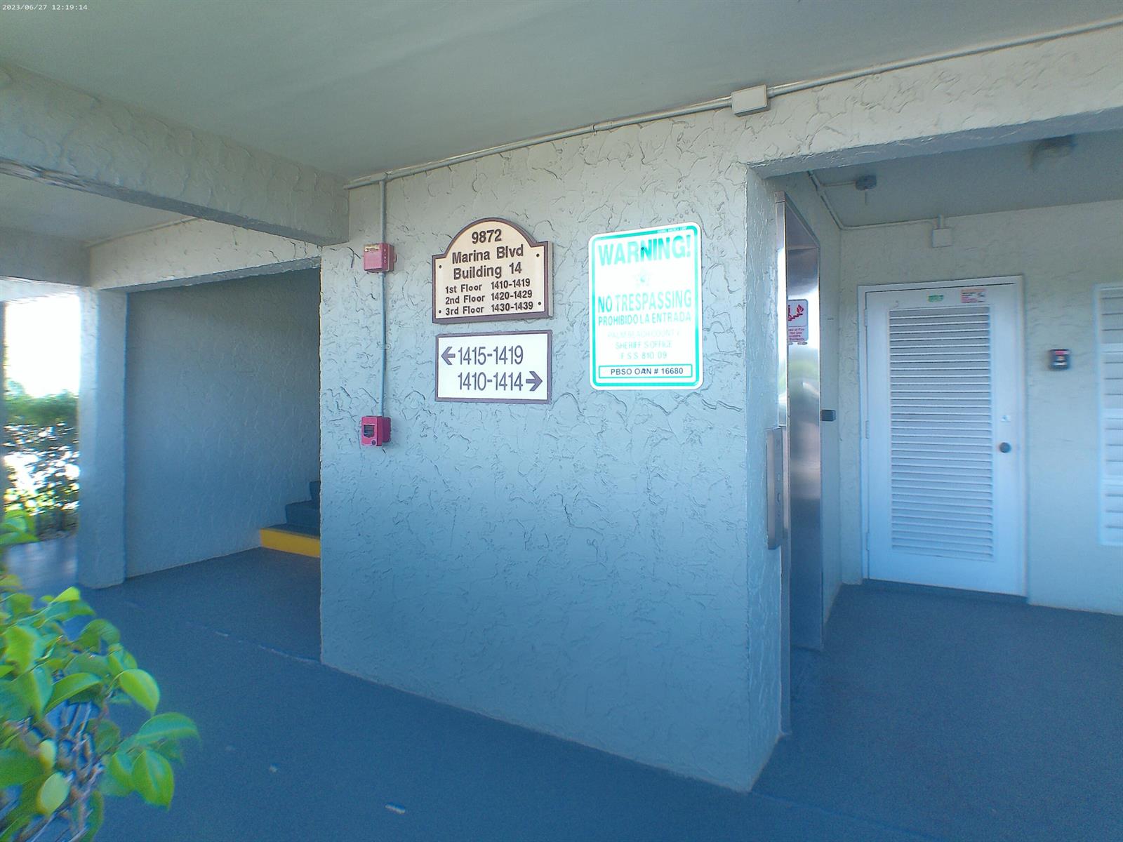 An outdoor walkway features a building directory sign, a no trespassing sign, and an elevator — 9872 Marina Boulevard # 1434, Boca Raton FL 33433, BOCA RATON, FL