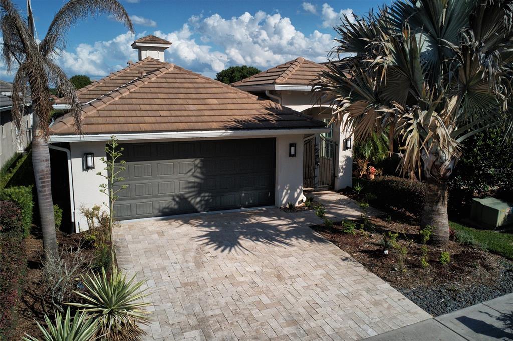 An exterior view of a house with a tiled roof, garage, and paved driveway — 2021 SHERBROOK AVENUE, DAVENPORT, FL