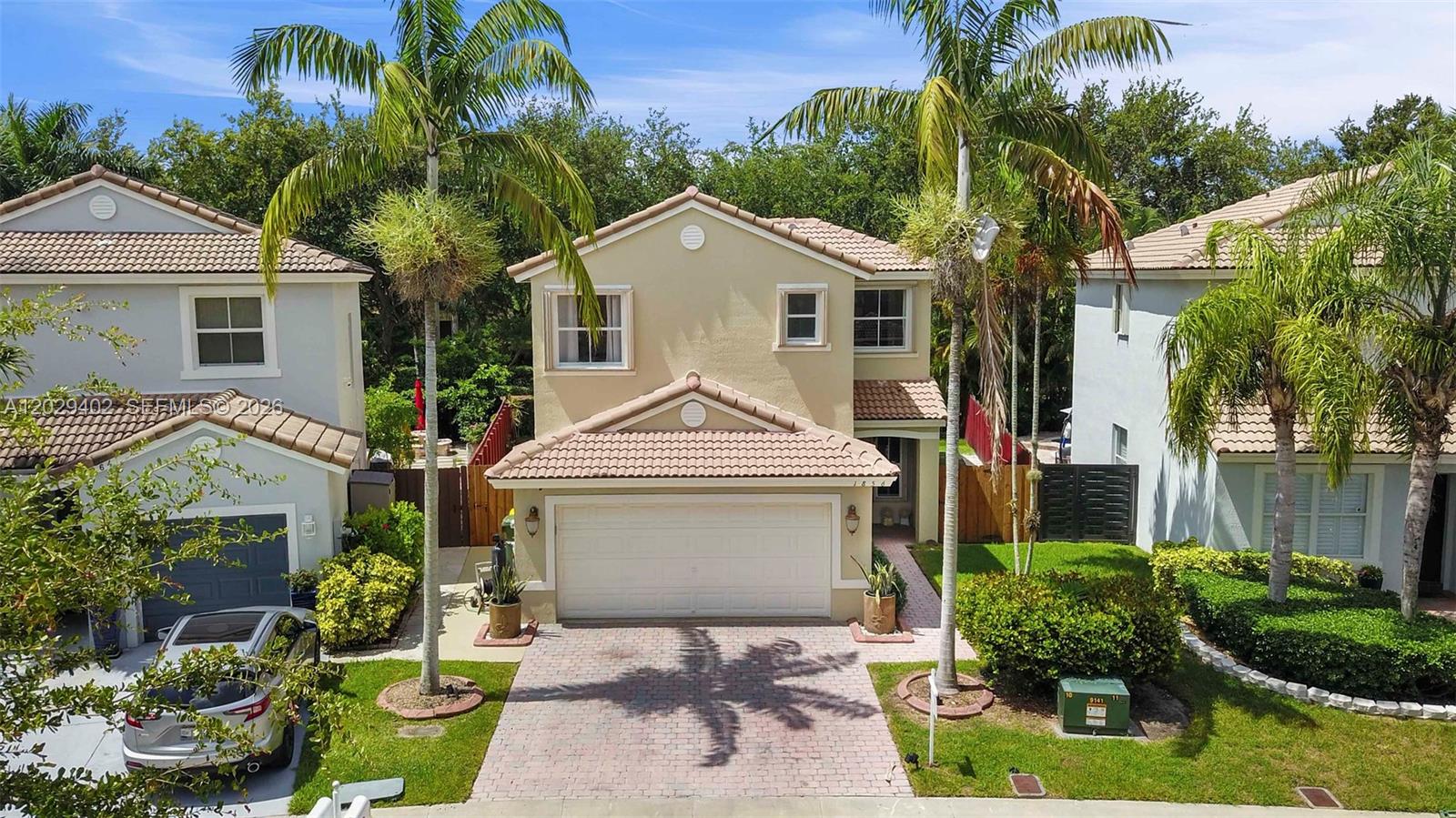 A two-story suburban house with a beige stucco exterior and a two-car garage — HOMESTEAD, FL