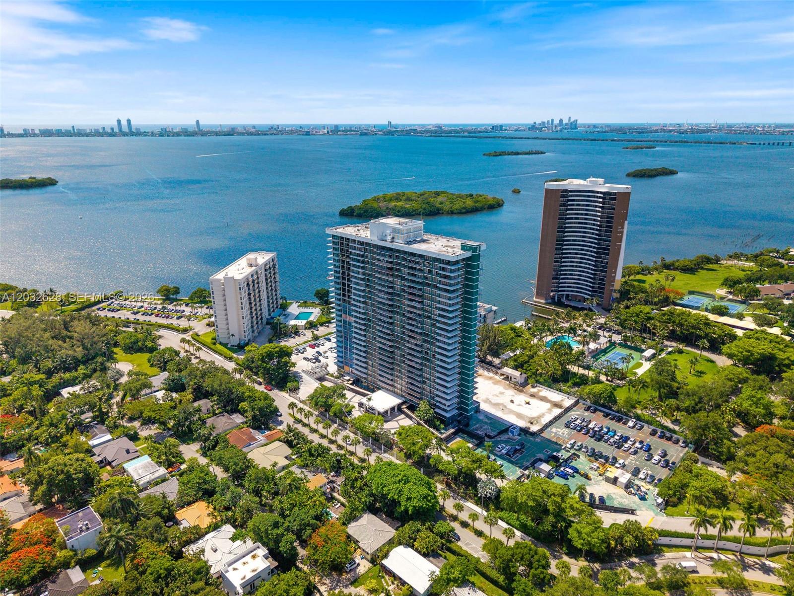 An aerial view shows three high-rise apartment buildings surrounded by trees and water — 780 NE 69th St # 2404, Miami FL 33138, MIAMI, FL