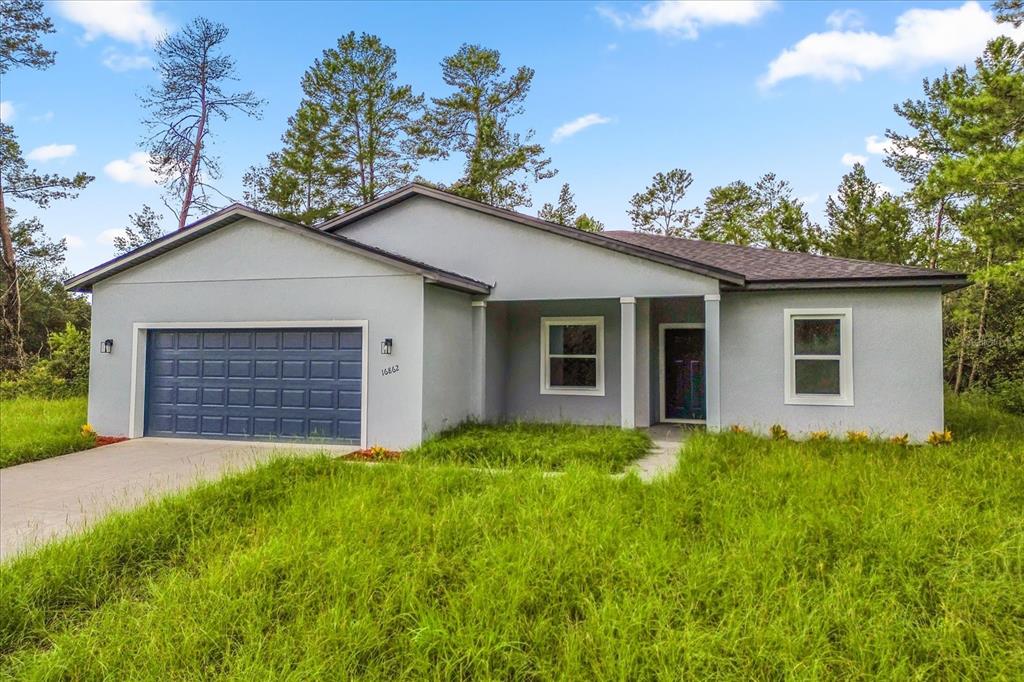 A single-story gray house with a blue garage door and a covered front entryway — 16862 SW 40TH CIR, OCALA, FL
