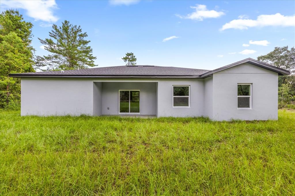 An aerial view shows a house with a dark shingled roof surrounded by wooded land — 16862 SW 40TH CIR, OCALA, FL