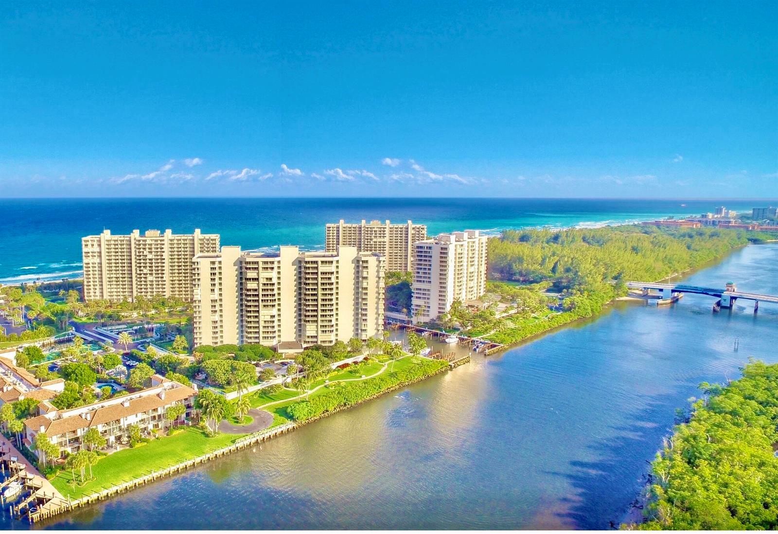 An aerial view shows high-rise apartment buildings situated between the ocean and a river — 4101 N Ocean Boulevard # 207, Boca Raton FL 33431, BOCA RATON, FL