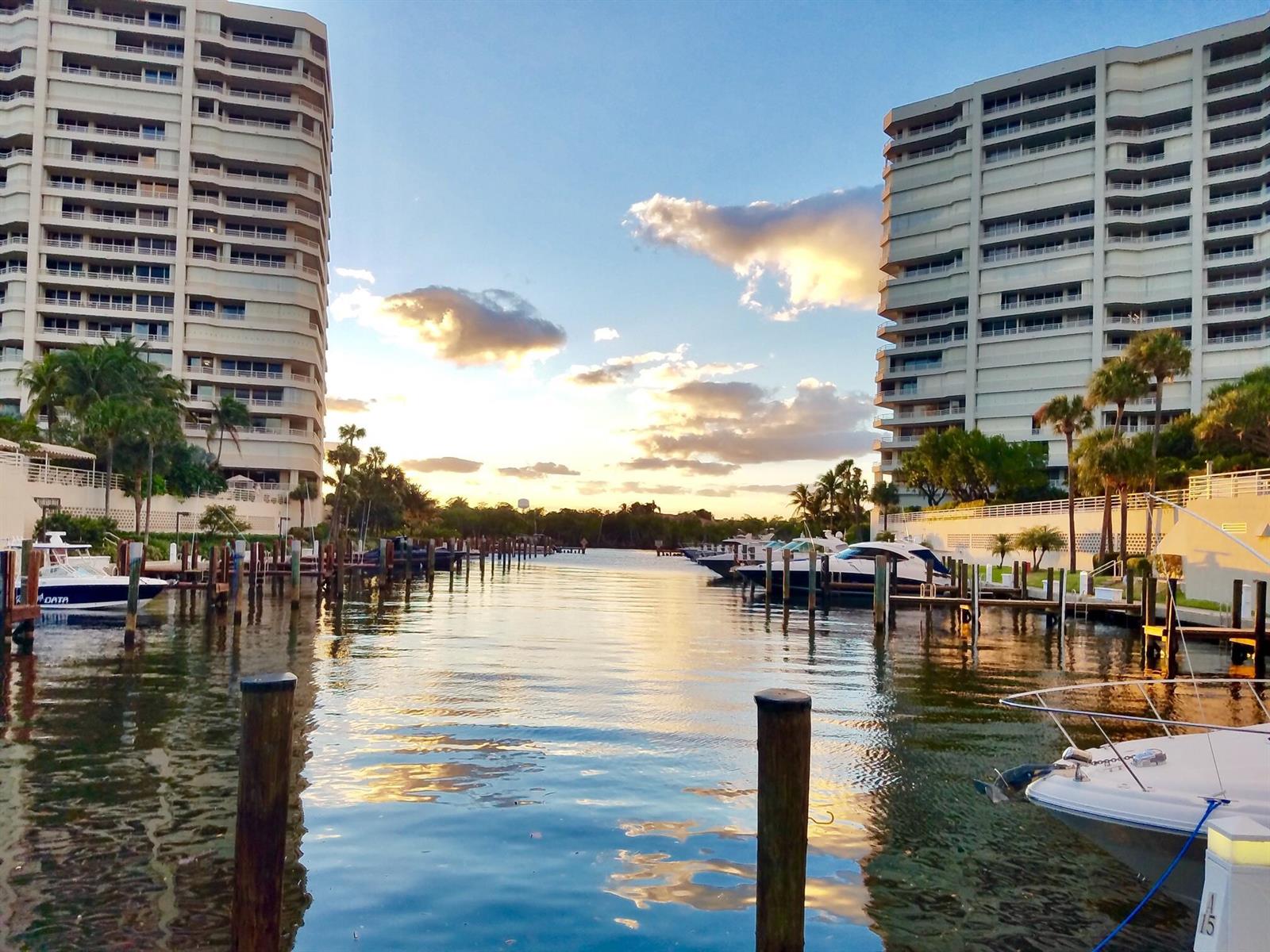 A canal view between two high-rise apartment buildings with docked boats at sunset — 4101 N Ocean Boulevard # 207, Boca Raton FL 33431, BOCA RATON, FL