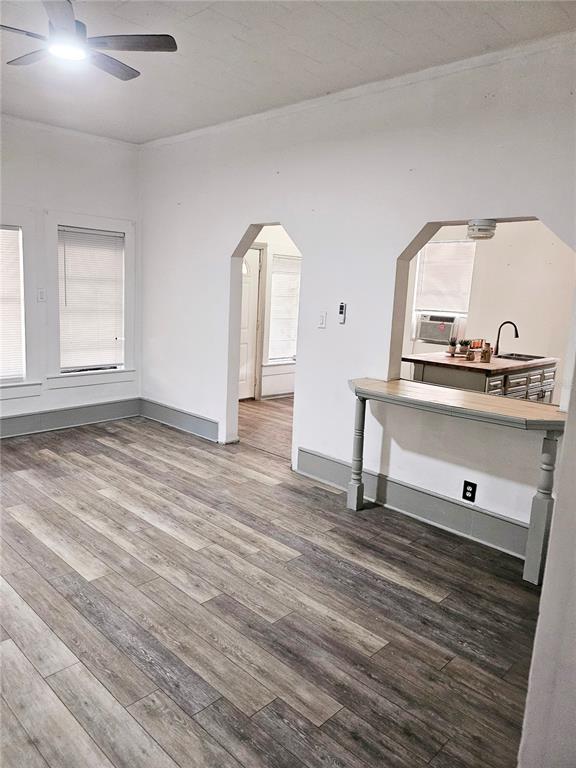 A living room with wood-look flooring, white walls, and a pass-through opening to the kitchen — 10250 SE 108TH TERRACE ROAD, OCALA, FL