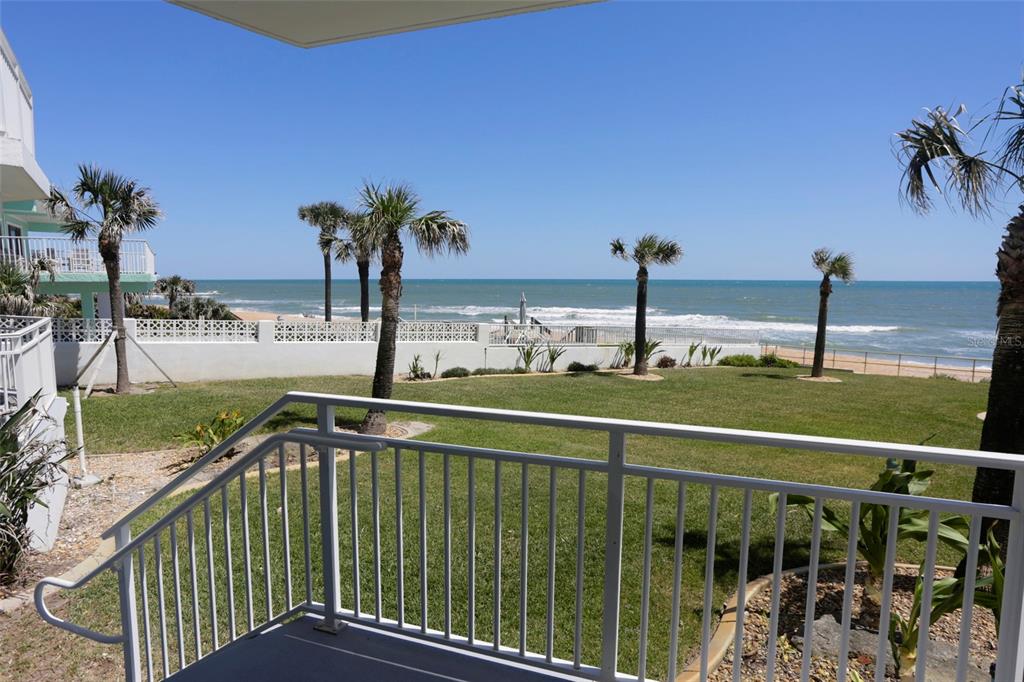 A view of a grassy lawn and the ocean from a white balcony railing — 1155 OCEAN SHORE BOULEVARD UNIT 102, ORMOND BEACH, FL
