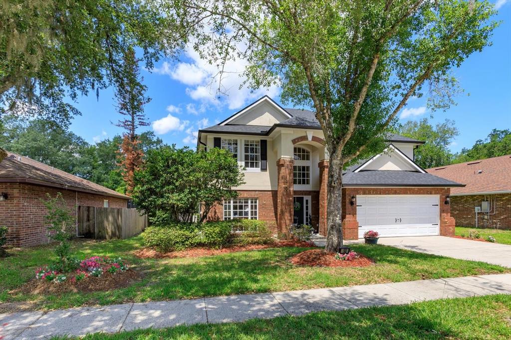 A two-story house with a brick and stucco exterior, a two-car garage, and mature trees — 50 OAK BEND COURT, OVIEDO, FL