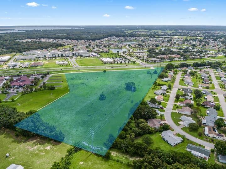 An aerial view shows a large, vacant, green-highlighted plot of land bordered by residential neighborhoods — 00 SE US HWY 441, SUMMERFIELD, FL