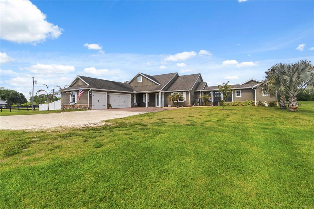 A single-story house with a two-car garage and a large grassy front yard — 4901 MANOR HOUSE LANE, ST CLOUD, FL
