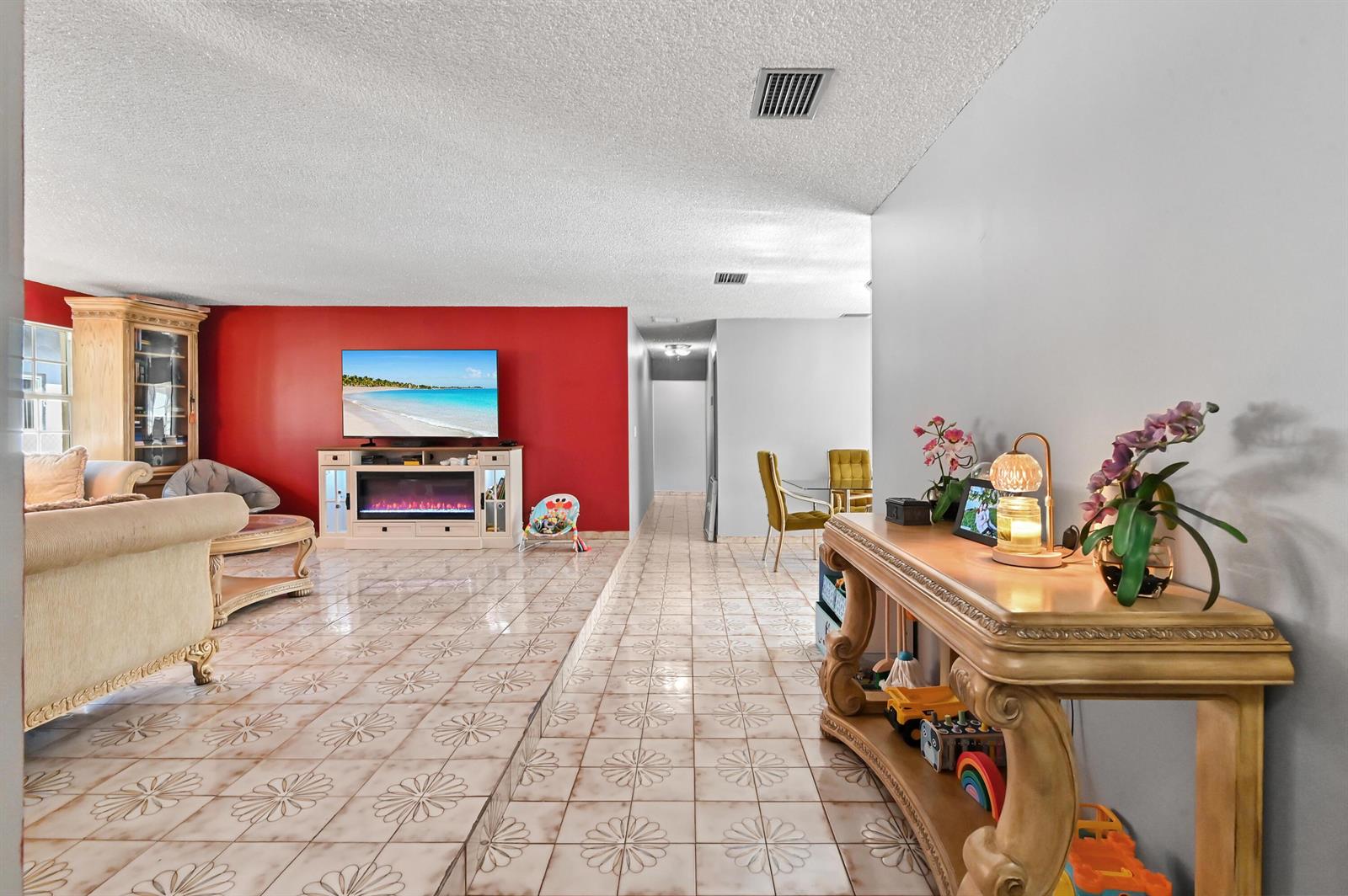 A living room features a sunken floor, red accent wall, fireplace, and tiled flooring — 7337 SW 21st Street, Miami FL 33155, MIAMI, FL
