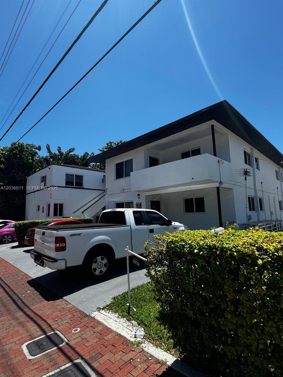 A white two-story apartment building stands behind a white pickup truck parked on a driveway — 602 SW 13th Ave # 4, Miami FL 33135, MIAMI, FL
